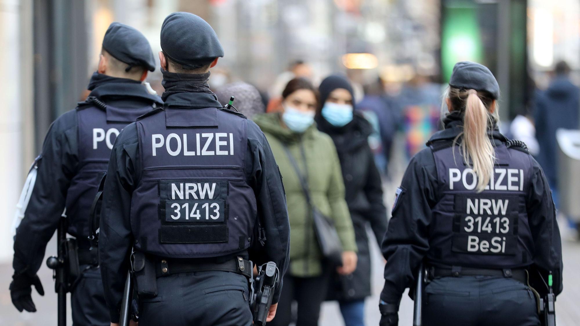 Polizisten laufen auf der Kölner Schildergasse Streife.