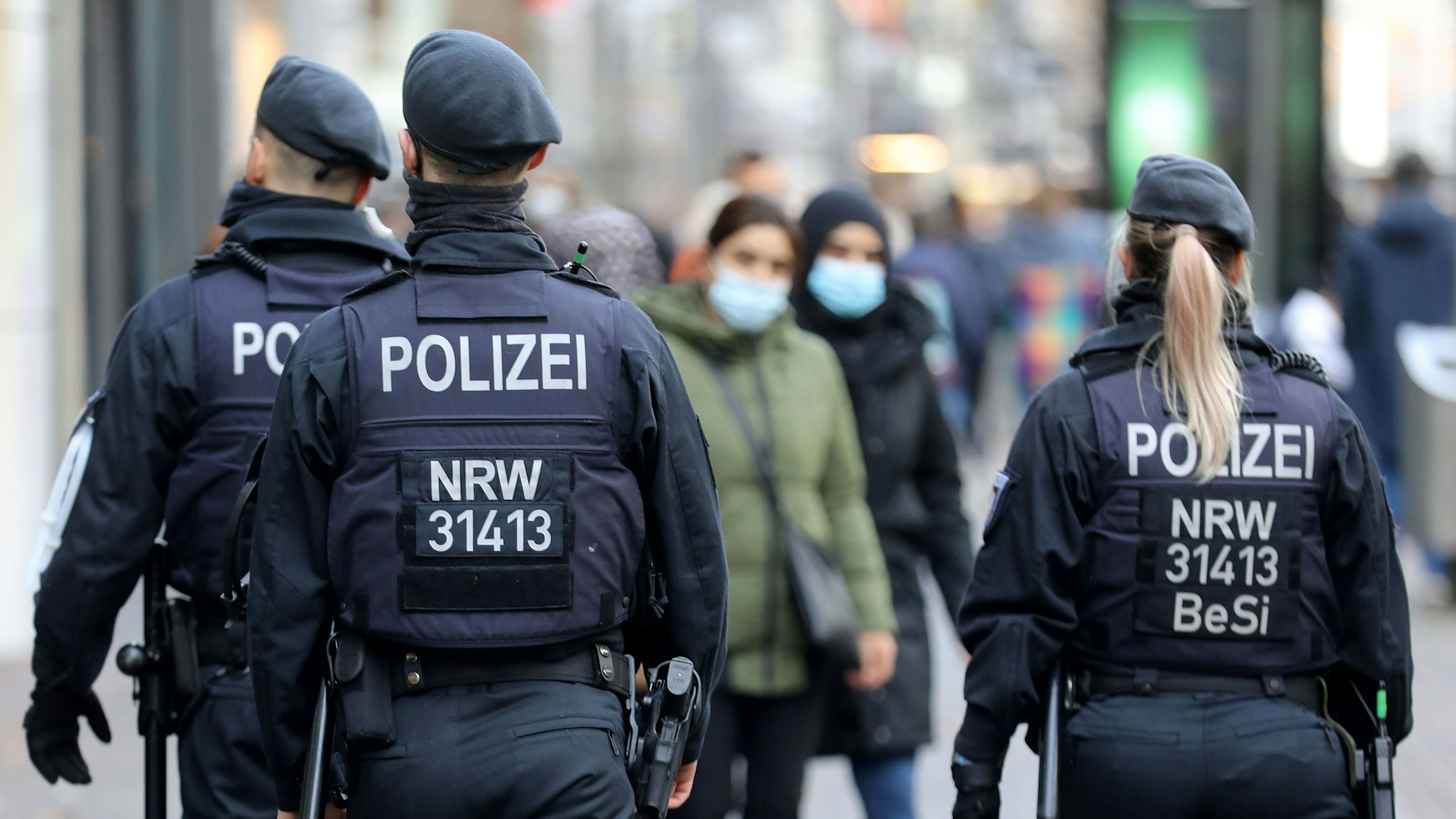 Polizisten laufen auf der Kölner Schildergasse Streife.
