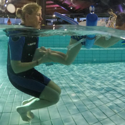 Das Bild zeigt Simone Schridde im Wasser mit einem Schwimmschüler.