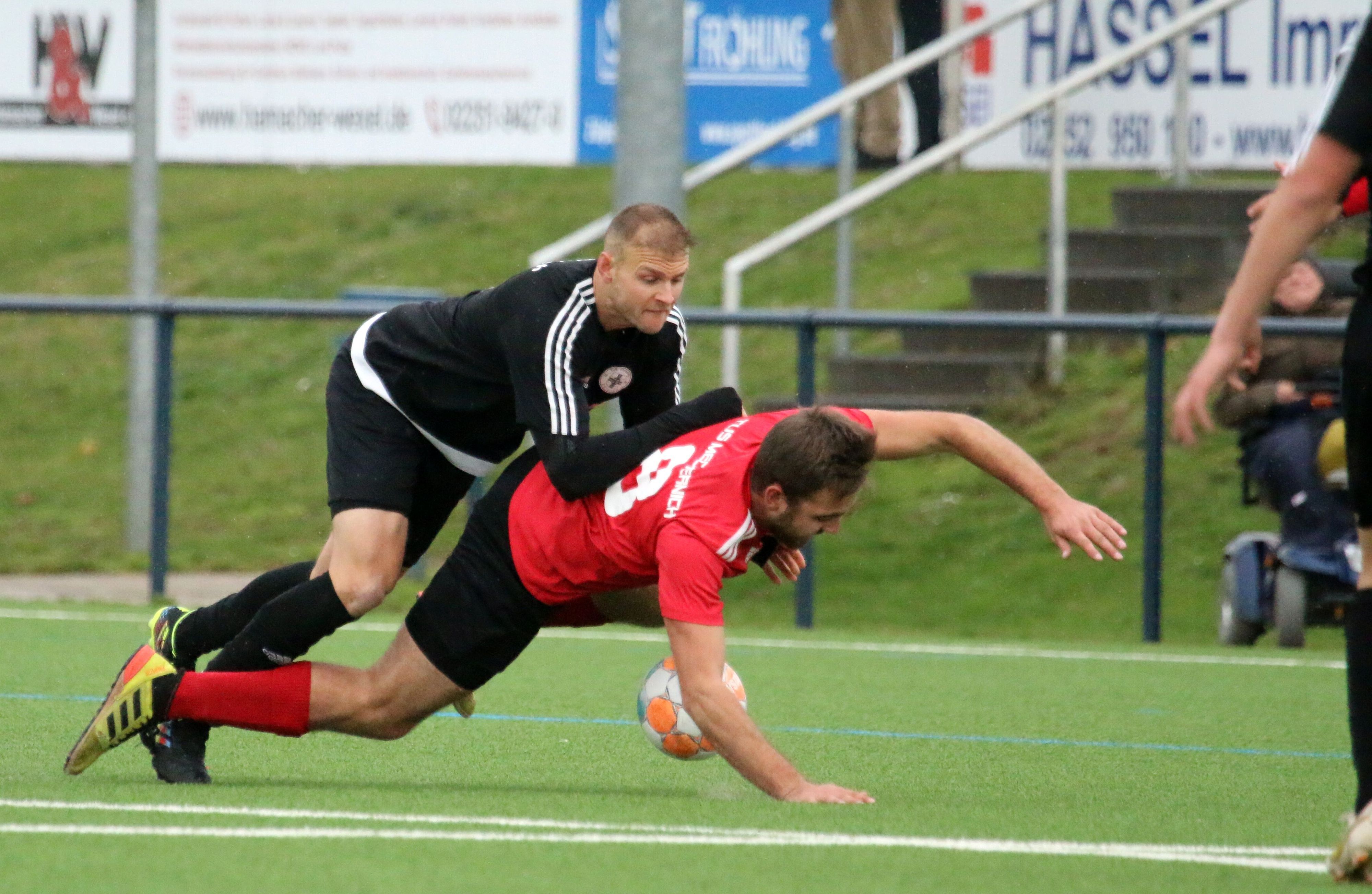 Der Zülpicher Spieler Markus Blum drückt von hinten Mechernichs Lukas Wollenweber zu Boden.