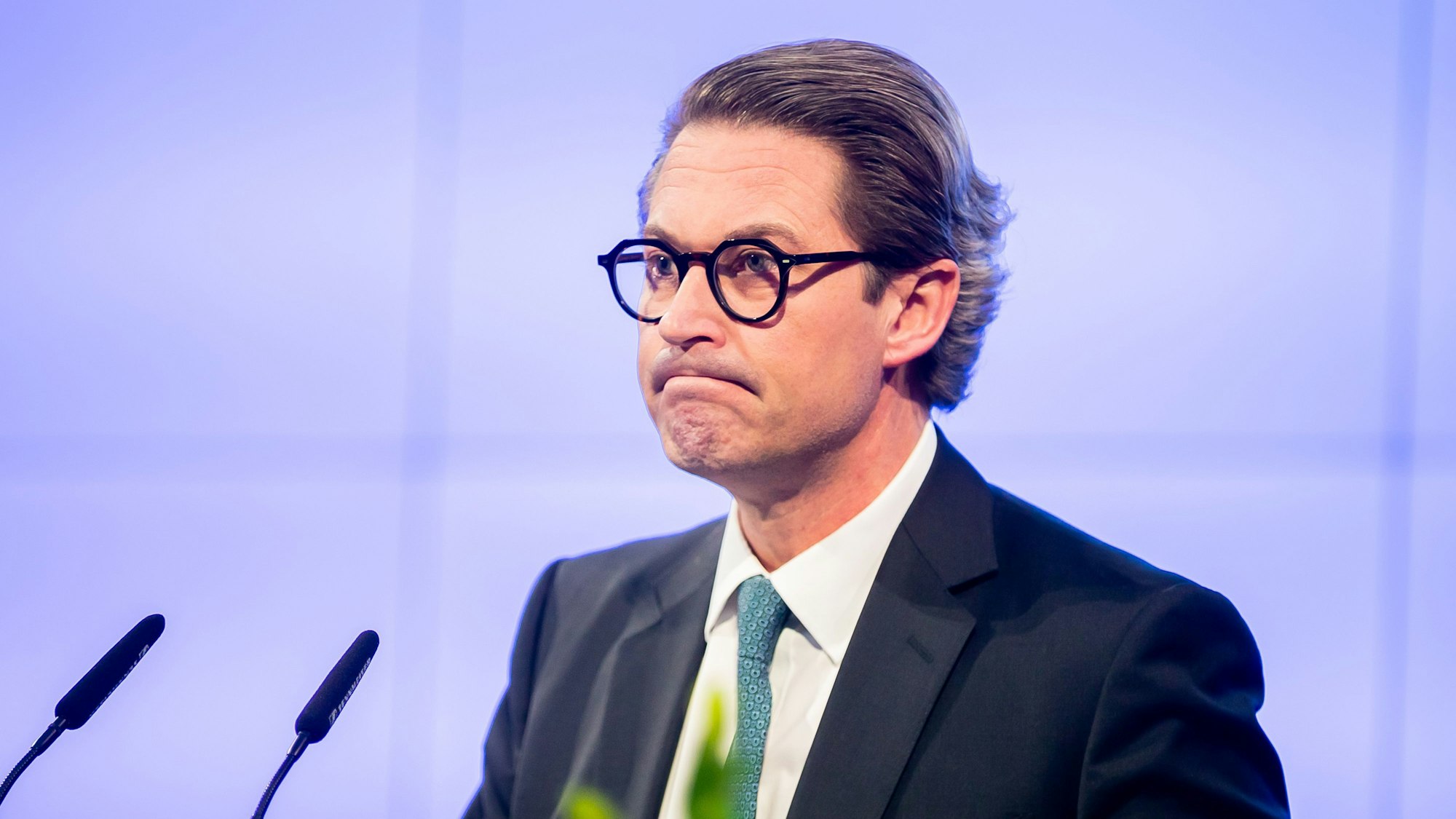 Ex-Bundesverkehrsminister Andreas Scheuer (CSU) vor einem Rednerpult mit zwei Mikrofonen.