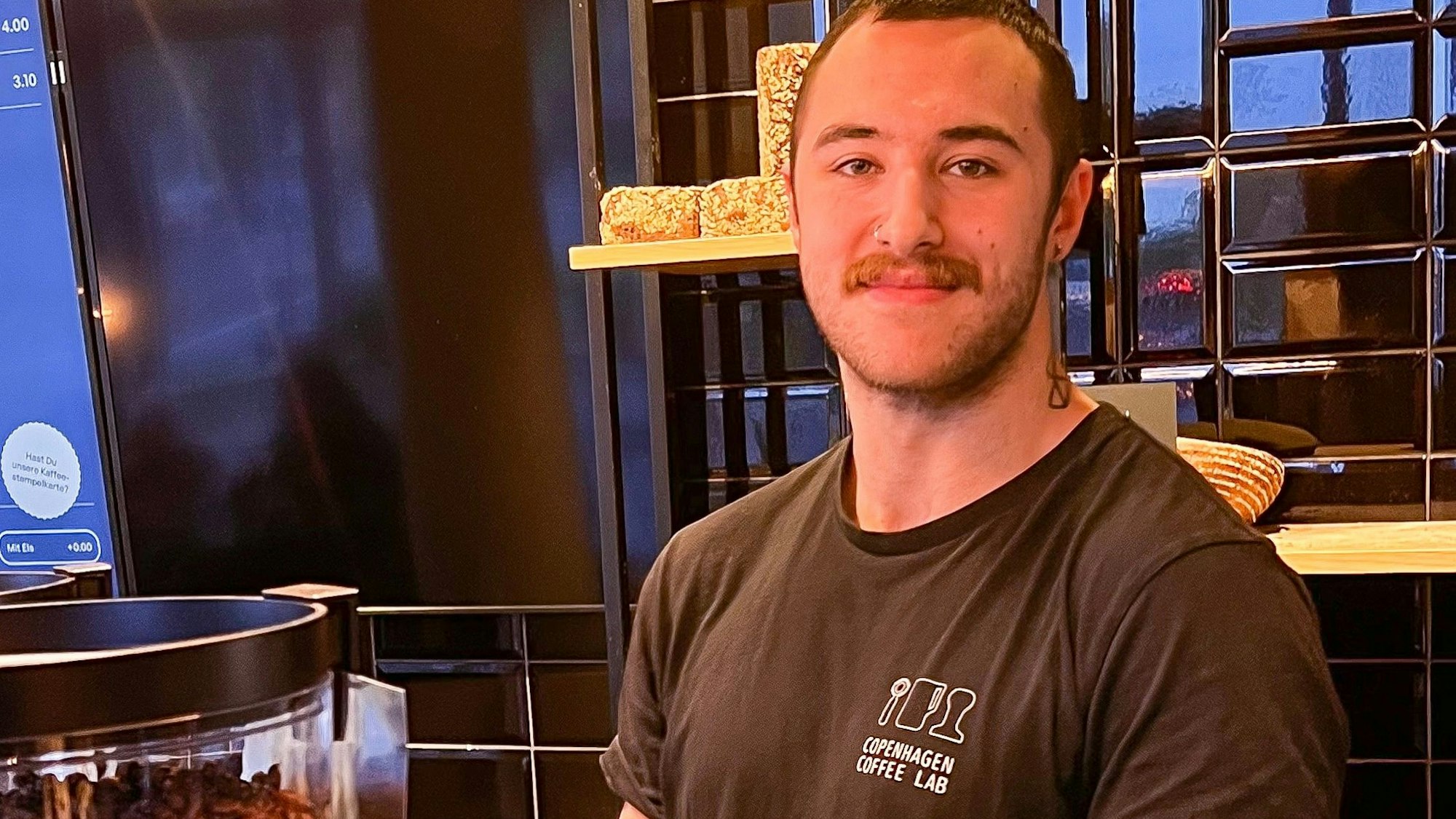 Deniz Özel, Chef-Barista der Filiale, steht hinter der Theke.