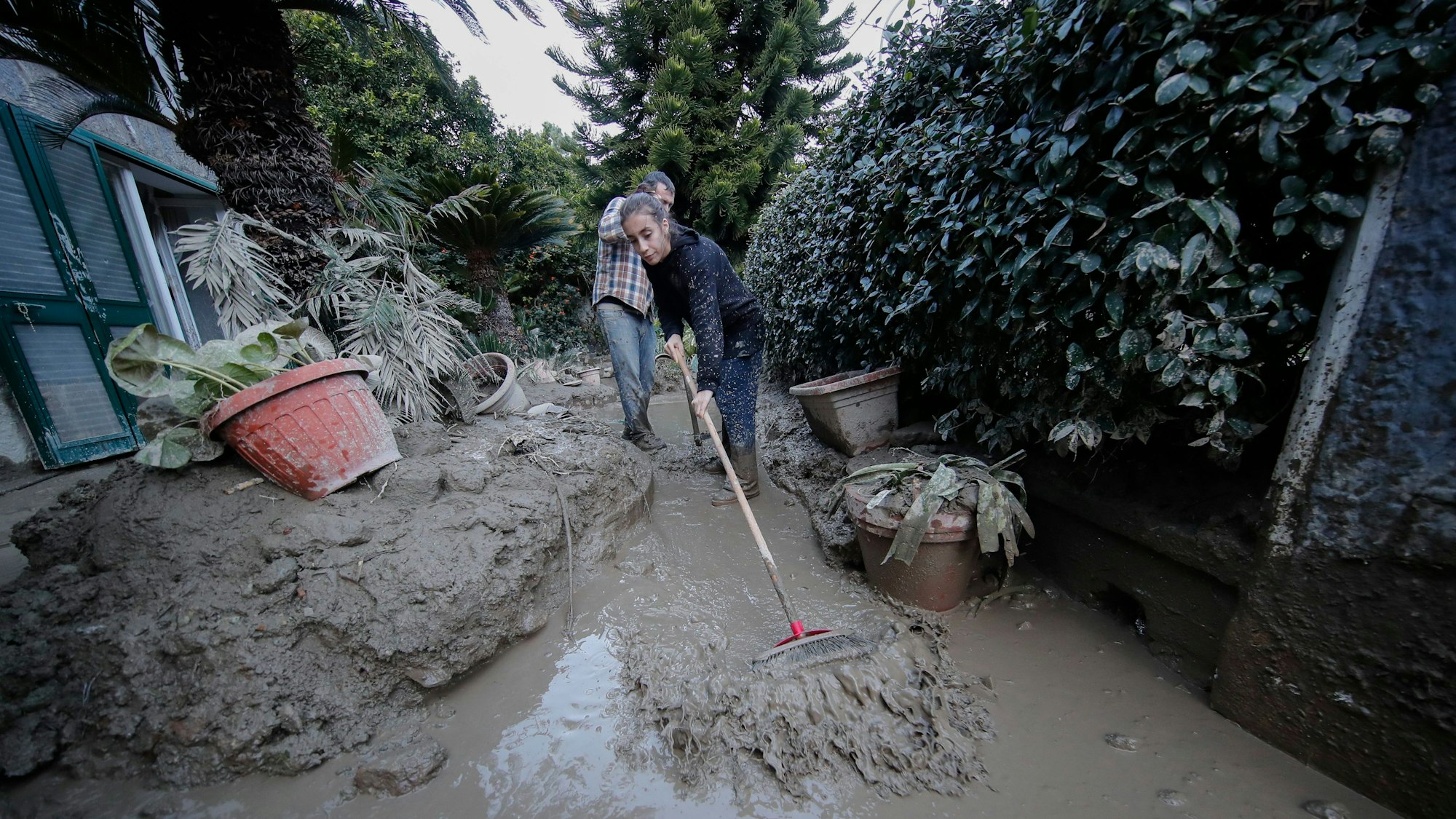 Menschen beseitigen Schlamm von den Straßen.