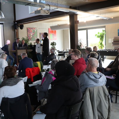 Die Bürgerinnen und Bürger schauen im Workshop auf eine Leinwand.