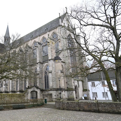 Der Altenberger Dom mit Bäumen ohne Blätter davor.