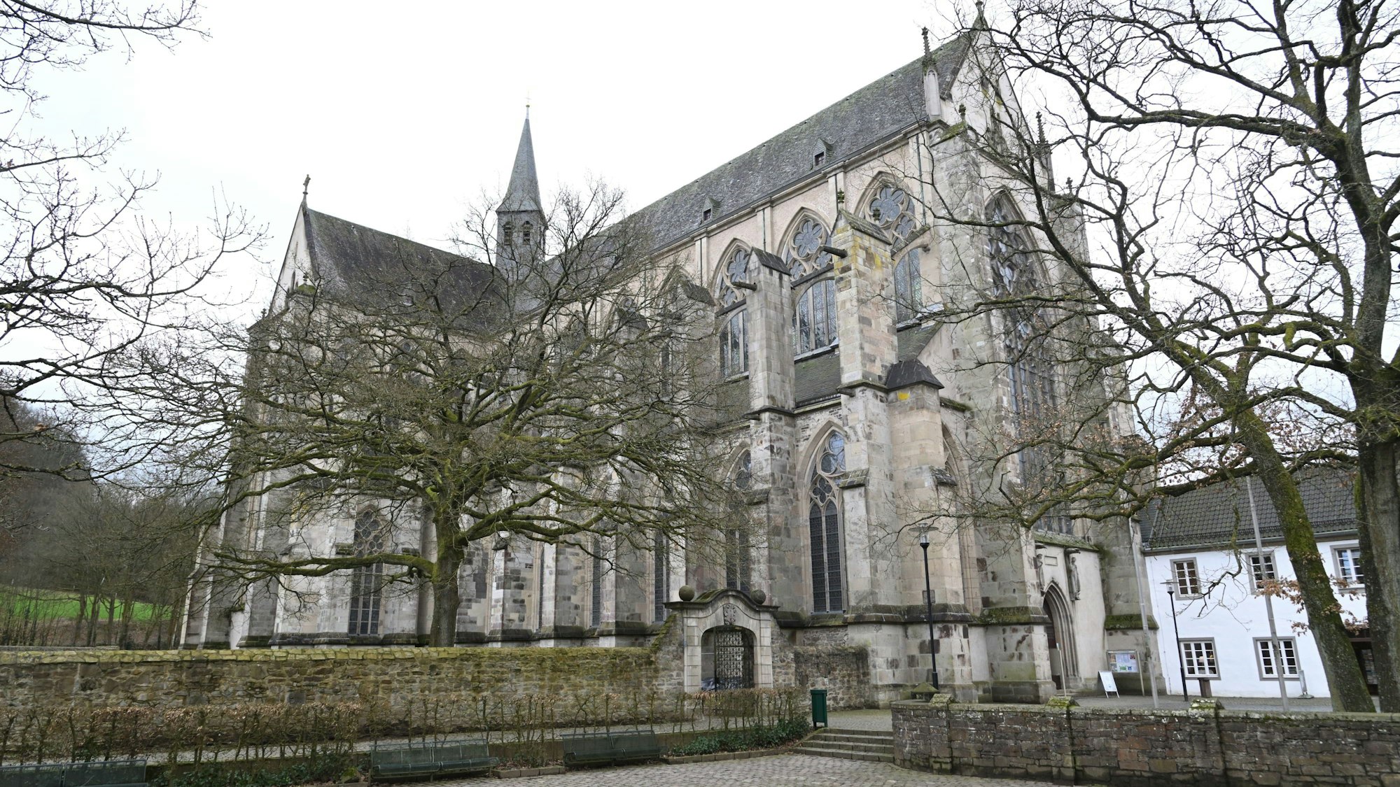 Der Altenberger Dom mit Bäumen ohne Blätter davor.