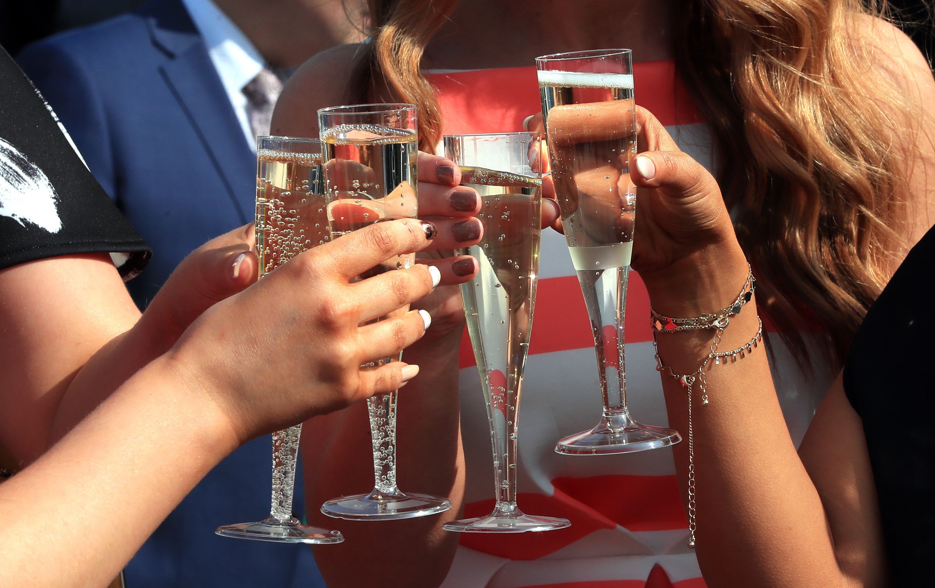 Eine Gruppe junger Menschen stößt mit Sekt an (Symbolbild)