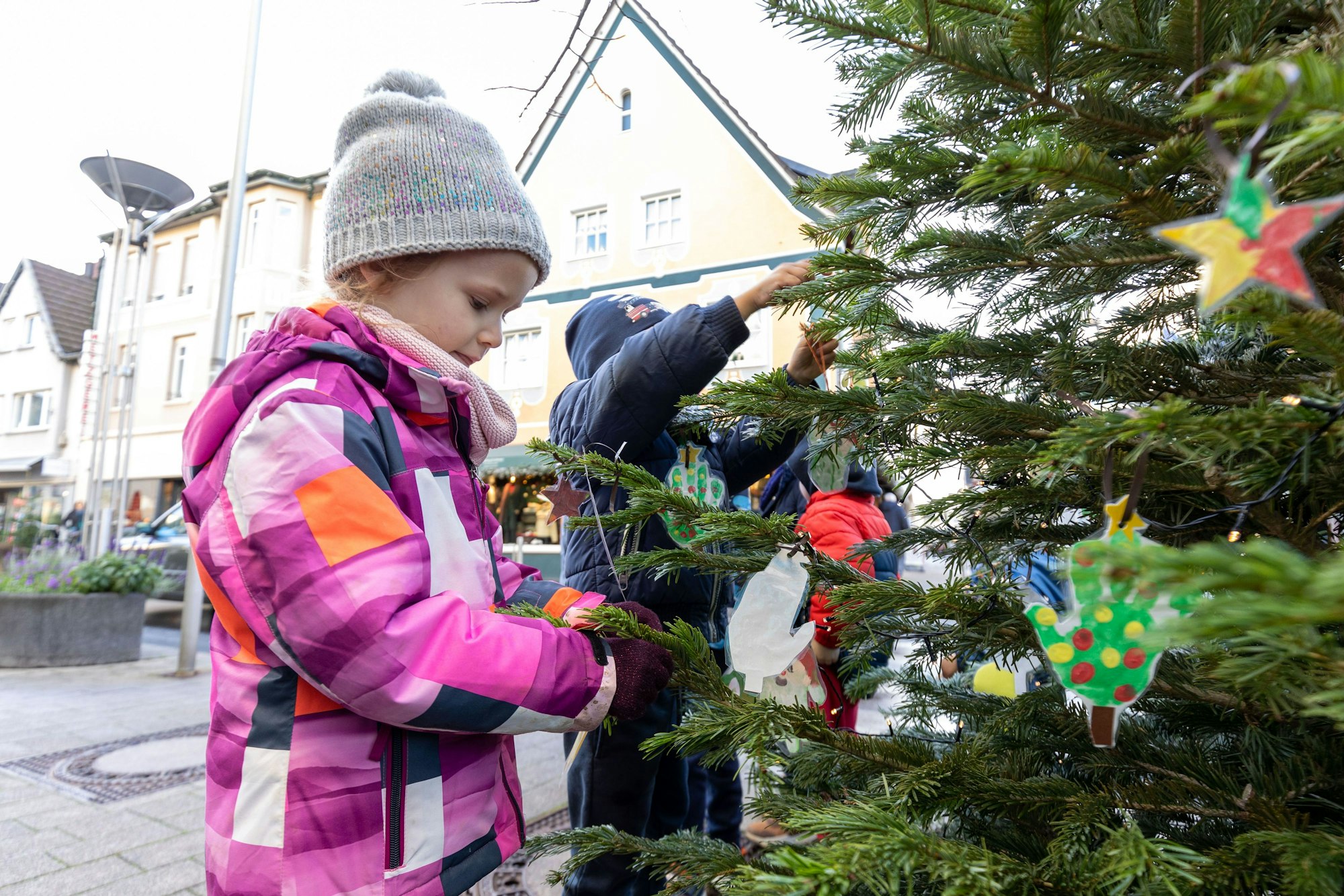 Emilia (4) und andere Kinder schmücken gemeinsam einen Weihnachtsbaum auf der Rheinbacher Hauptstraße.