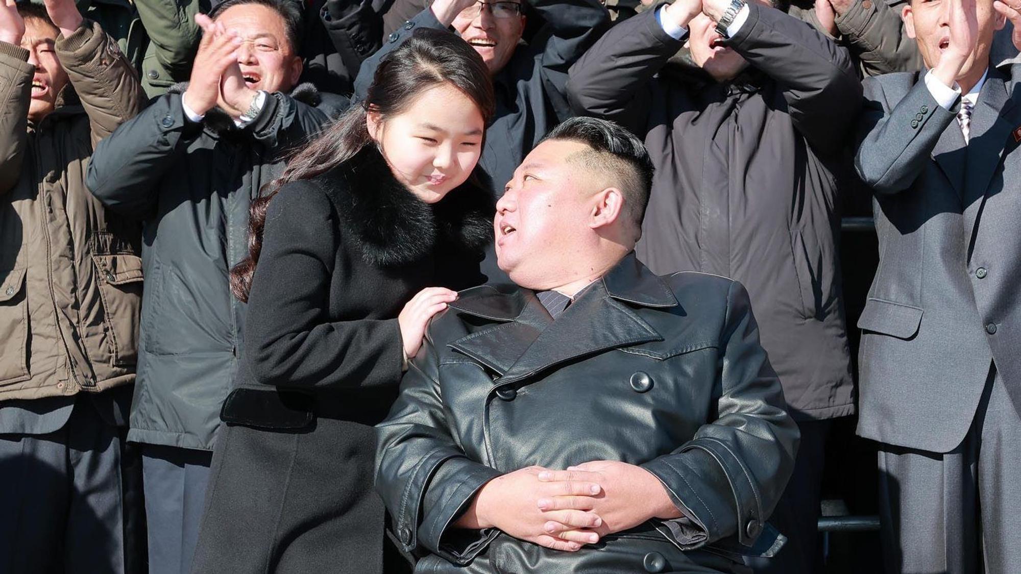 Kim Jong Un und seine Tochter unterhalten sich, im Hintergrund feiern nordkoreanische Bürger das Duo.