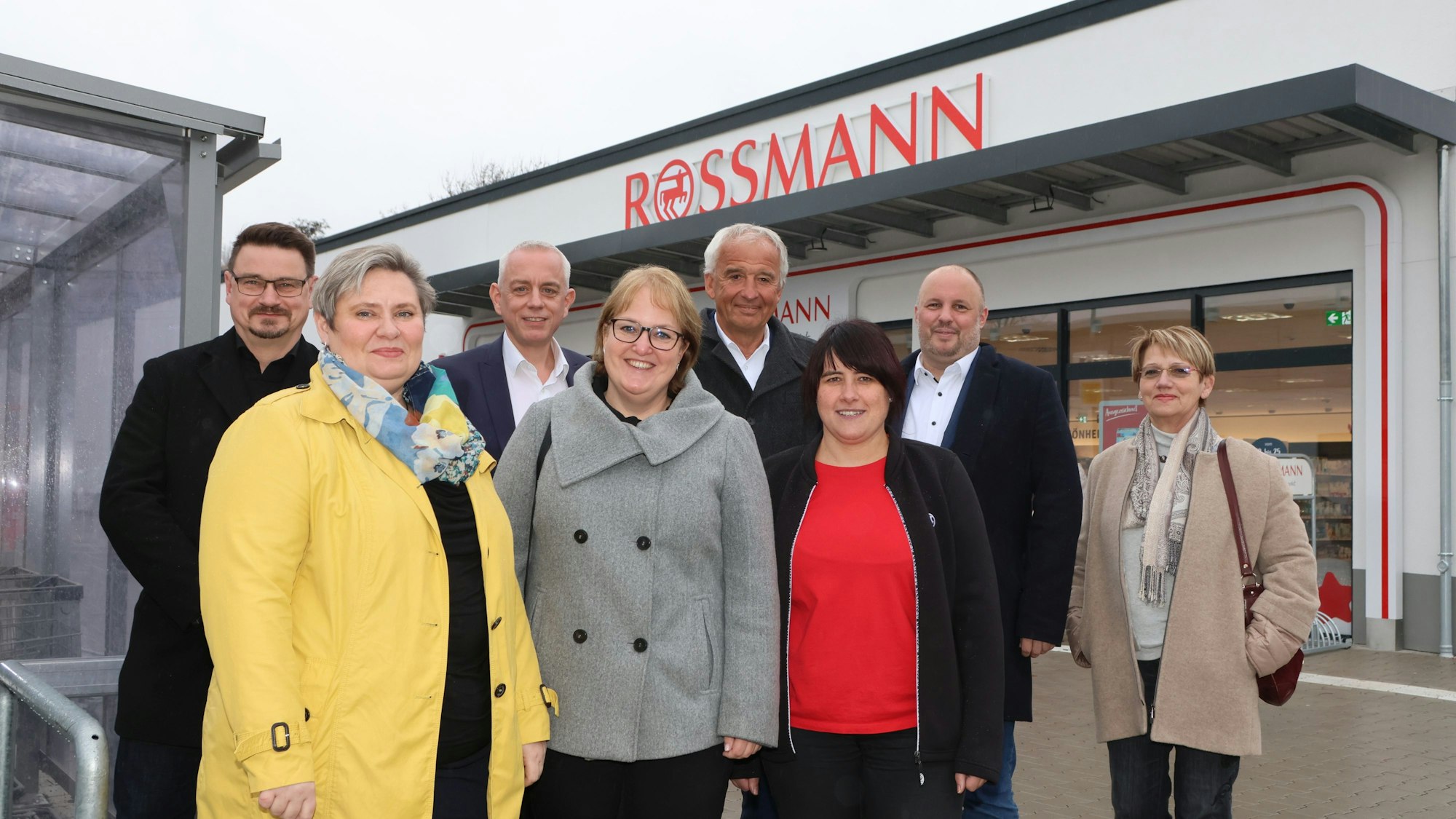 Männer und Frauen stehen vor einem Drogeriemarkt in Bergneustadt.