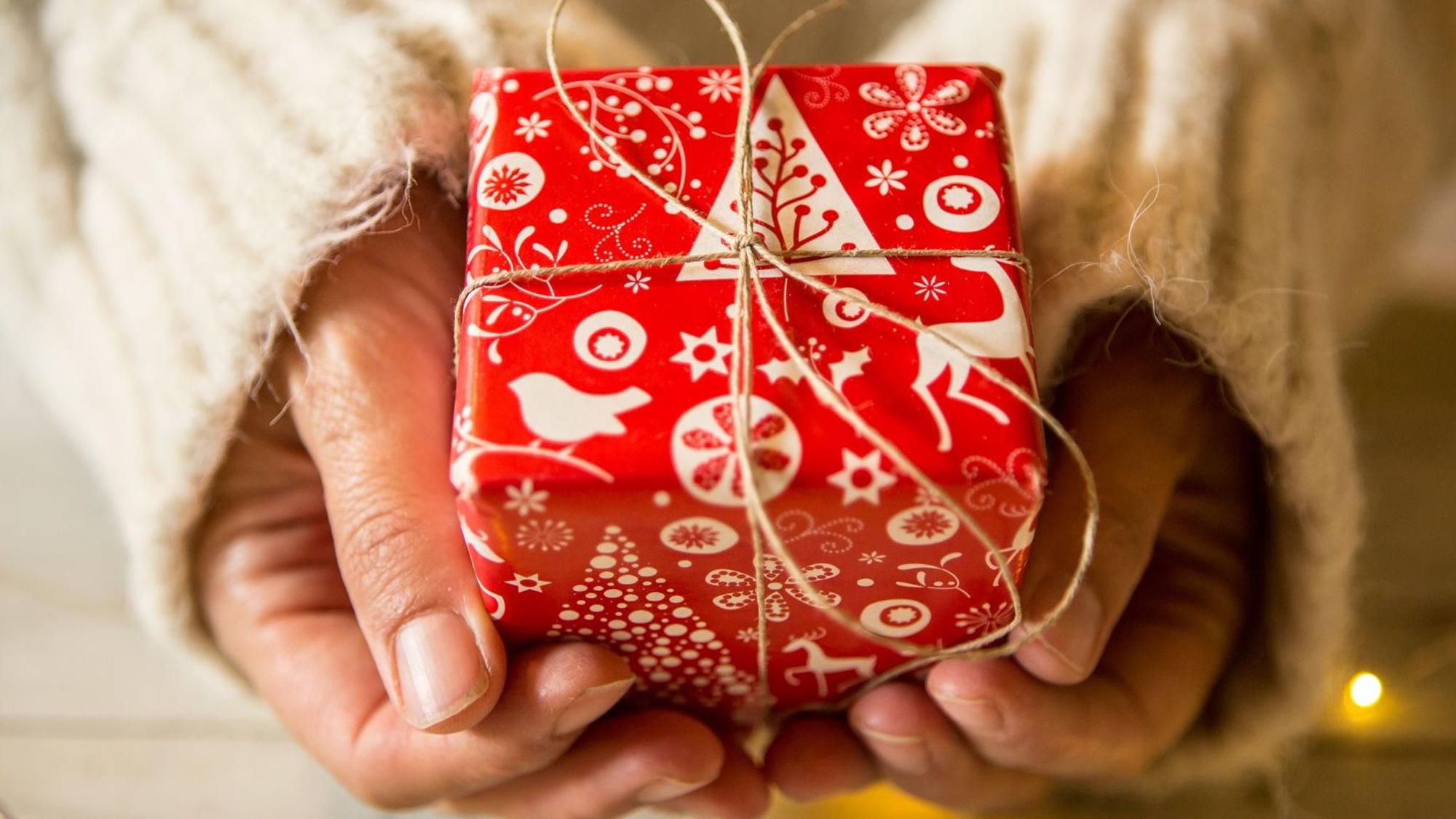 Hände halten ein Weihnachtsgeschenk