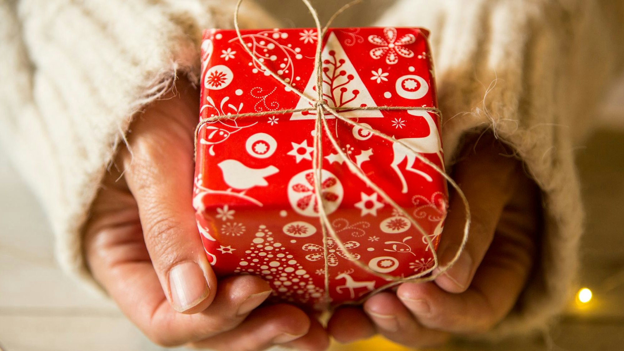 Hände halten ein Weihnachtsgeschenk