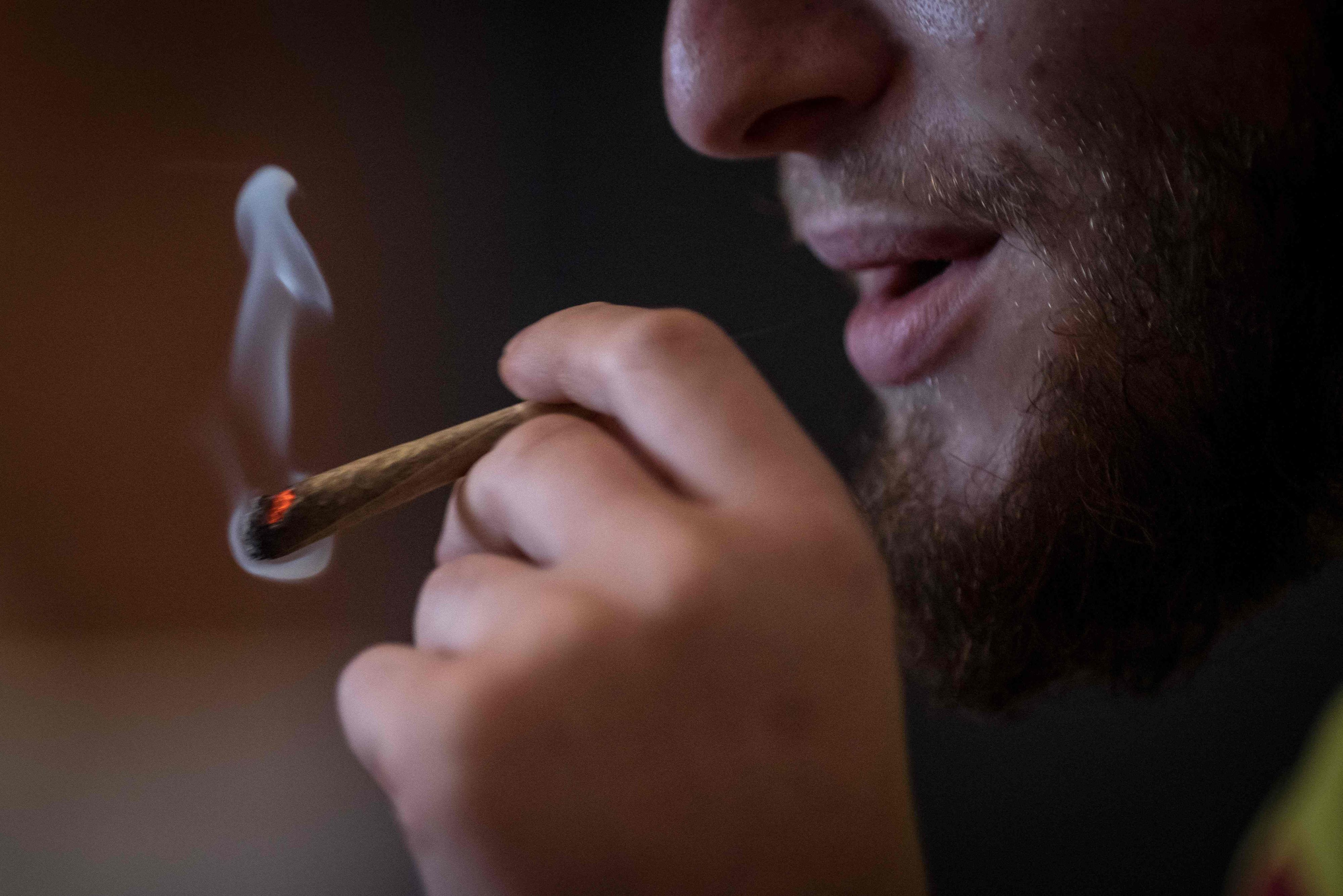 Ein Mann raucht einen Joint.