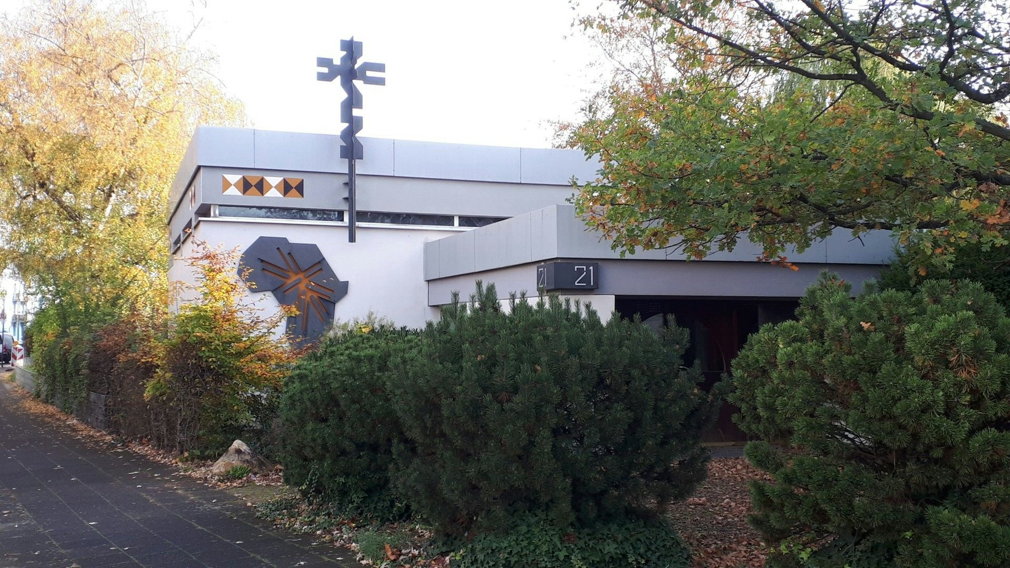 Das Bild zeigt einen Flachbau mit dem Symbol des Ordens der Weißen Väter und dem Umriss Afrikas aus Metall an der Außenwand.