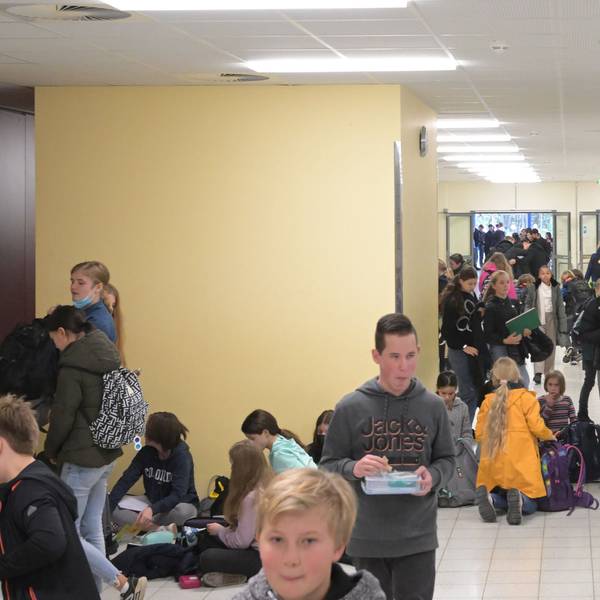 Schülerinnen und Schüler des Gymnasiums Herkenrath in Bergisch Gladbach sitzen in einem Gang.