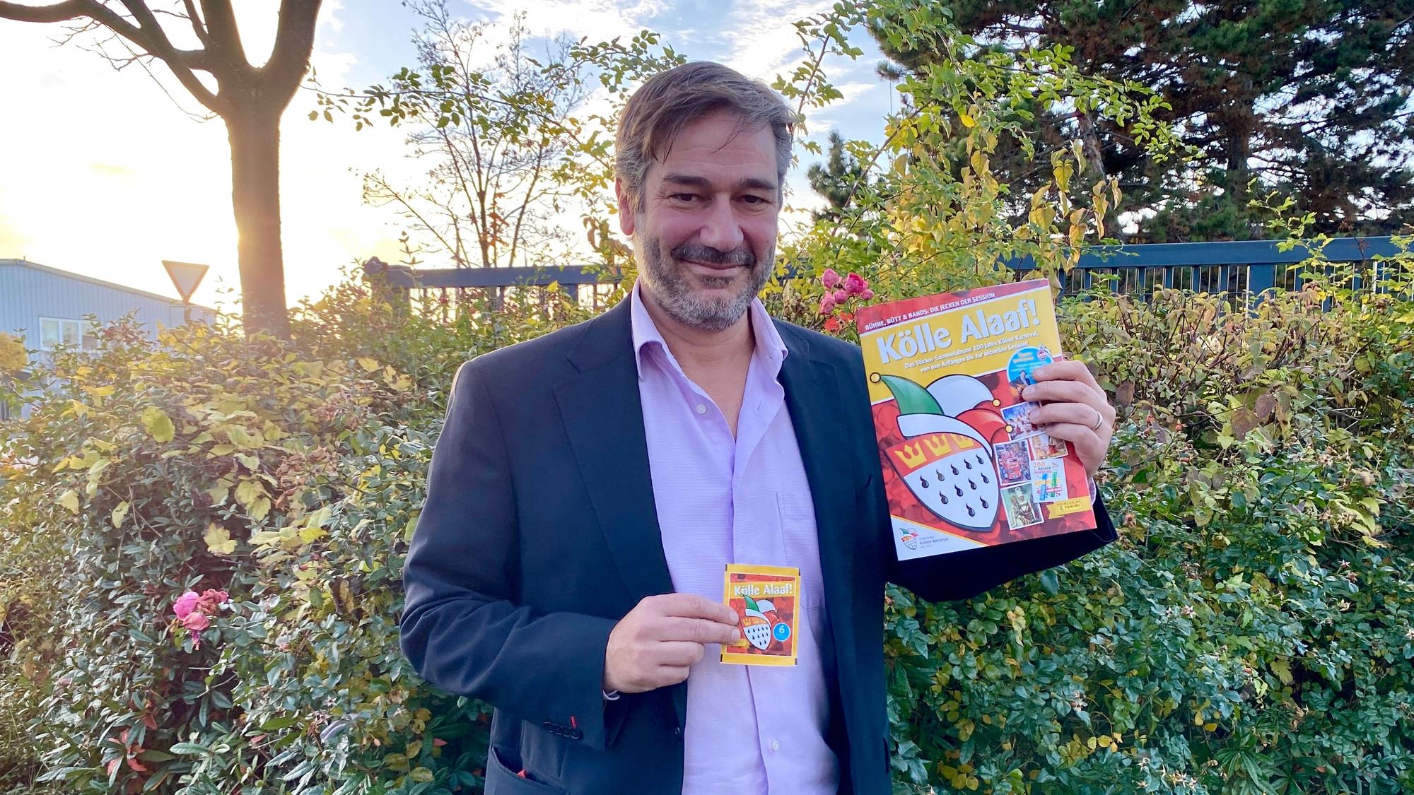Thomas Schmitz hält das Panini-Album in der Hand.
