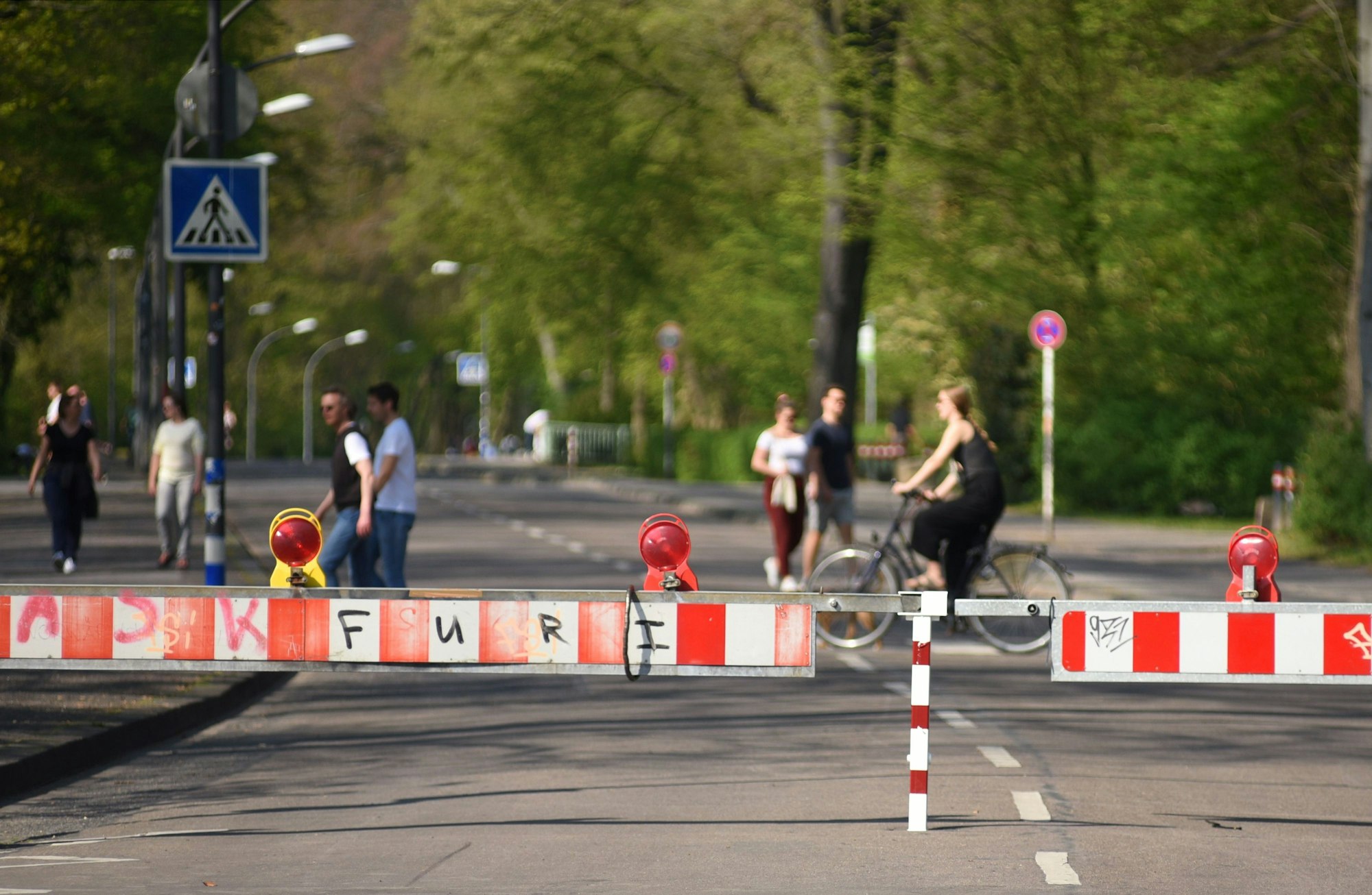 Gesperrte Kitschburger Straße mit Fahrradfahrerin und Fußgängern.