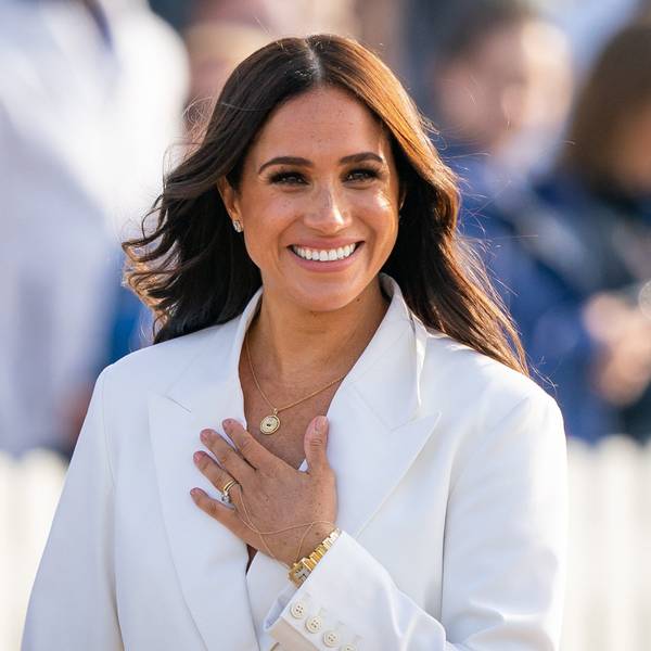 Meghan, Herzogin von Sussex, läuft lächelnd vor einer großen Menge entlang.