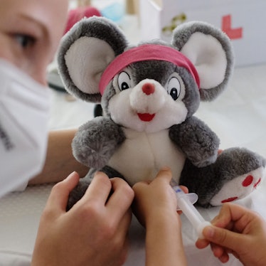 Eine Ärztin übt zusammen mit einer kleinen Patienten, wie man eine Spritze setzt. (Symbolbild)