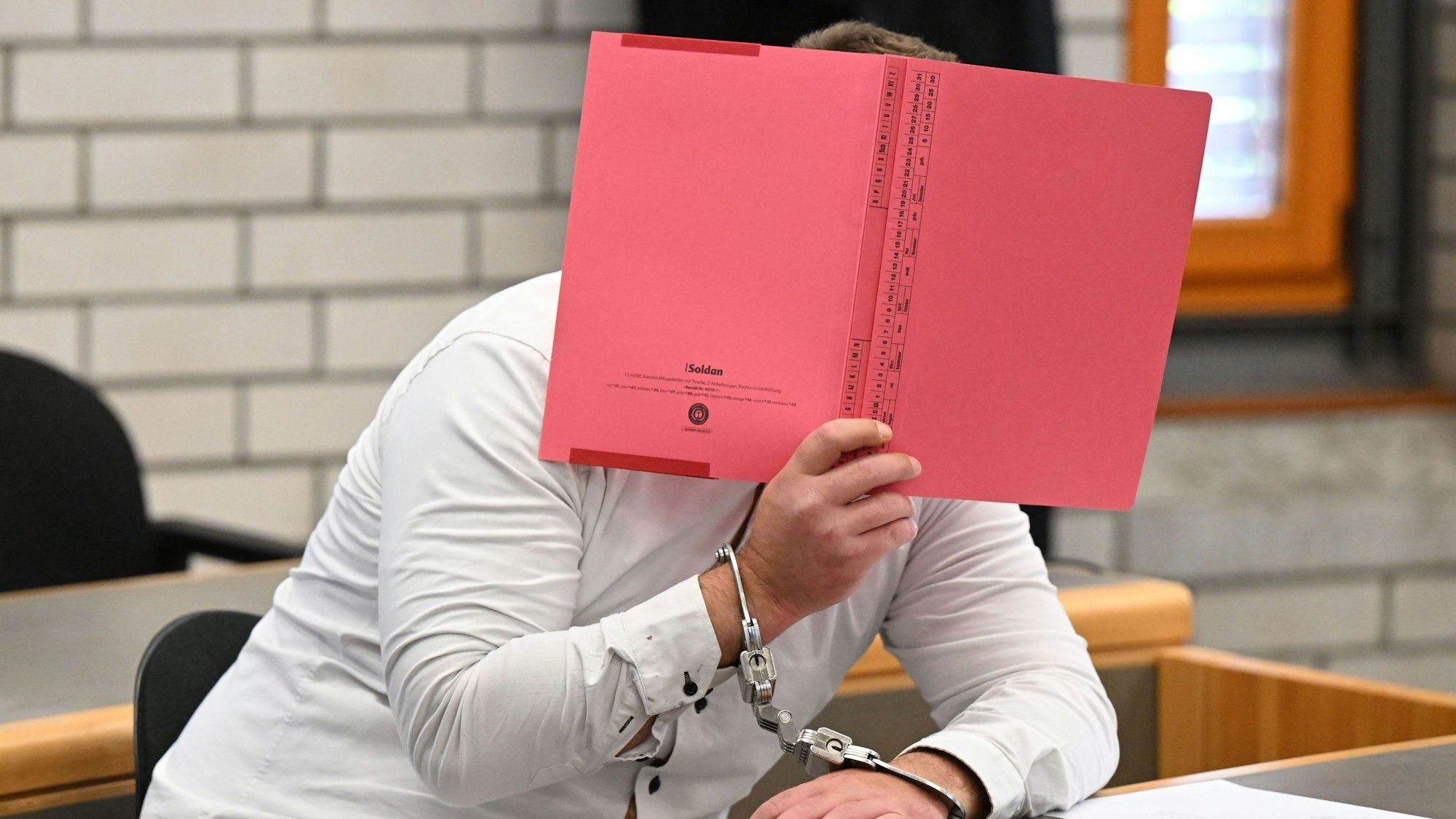 Der Angeklagte im Prozess wegen Mordes an einer Sechsjährigen und Störung der Totenruhe wartet in einem Verhandlungssaal im Landgericht Baden-Baden auf den Prozessbeginn.
