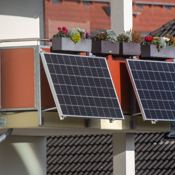 Solarmodule für ein sogenanntes "Balkonkraftwerk" hängen an einem Balkon.