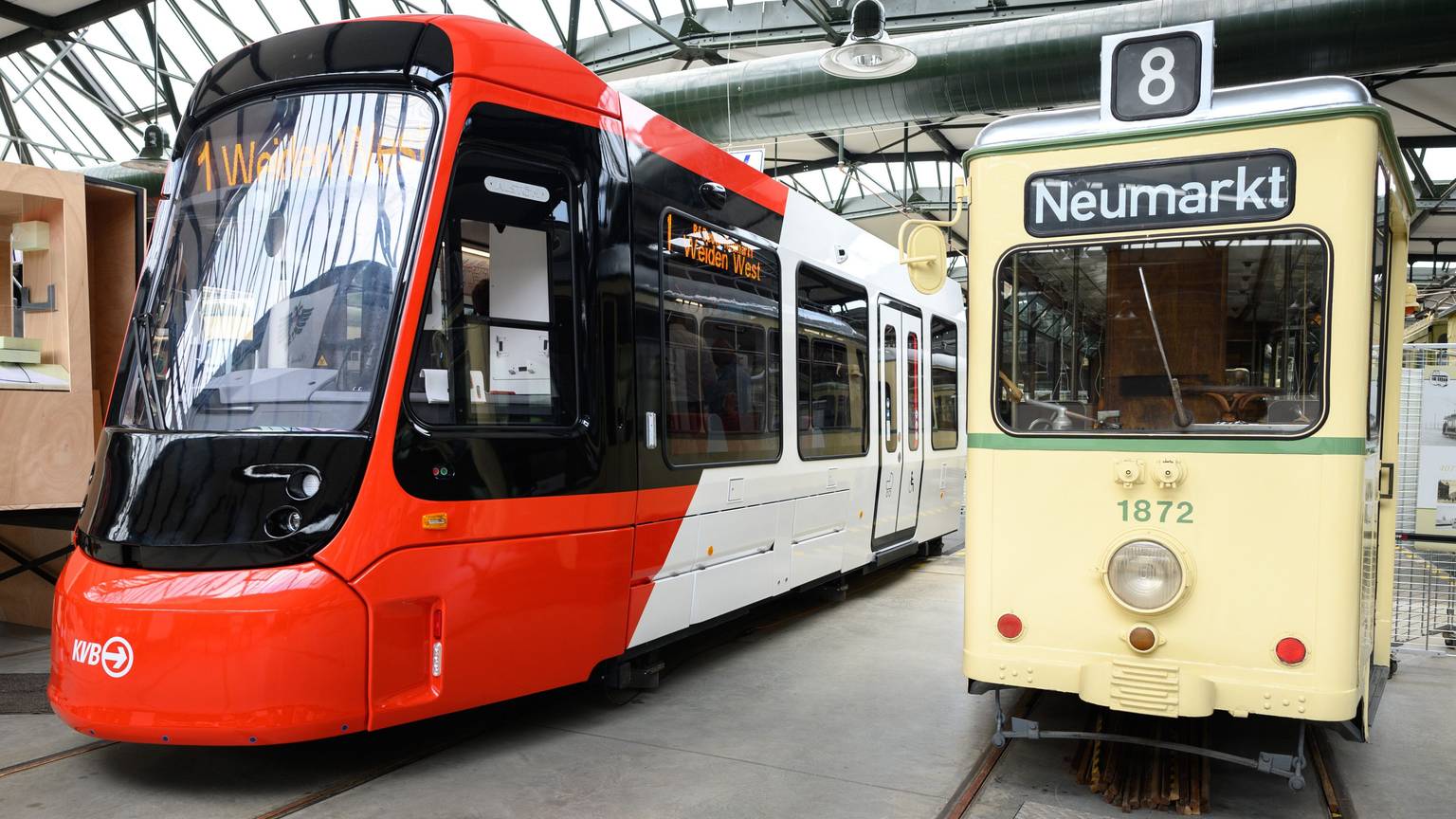 Für viele Menschen im Rollstuhl nicht eigenständig nutzbar, lautet die Kritik am neuen Niederflurmodell. Die rot-weiß lackierte Straßenbahn wurde in der Halle des Bahnhofs Thielenbruch neben dem deutlich kleineren hellgelben Modell aus den Anfangsjahren der KVB gezeigt.