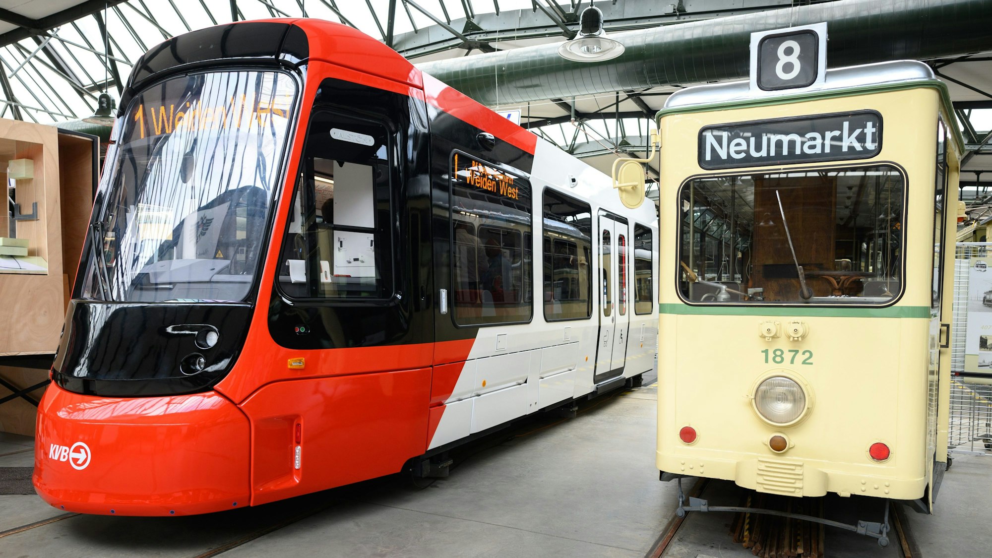 Für viele Menschen im Rollstuhl nicht eigenständig nutzbar, lautet die Kritik am neuen Niederflurmodell. Die rot-weiß lackierte Straßenbahn wurde in der Halle des Bahnhofs Thielenbruch neben dem deutlich kleineren hellgelben Modell aus den Anfangsjahren der KVB gezeigt.