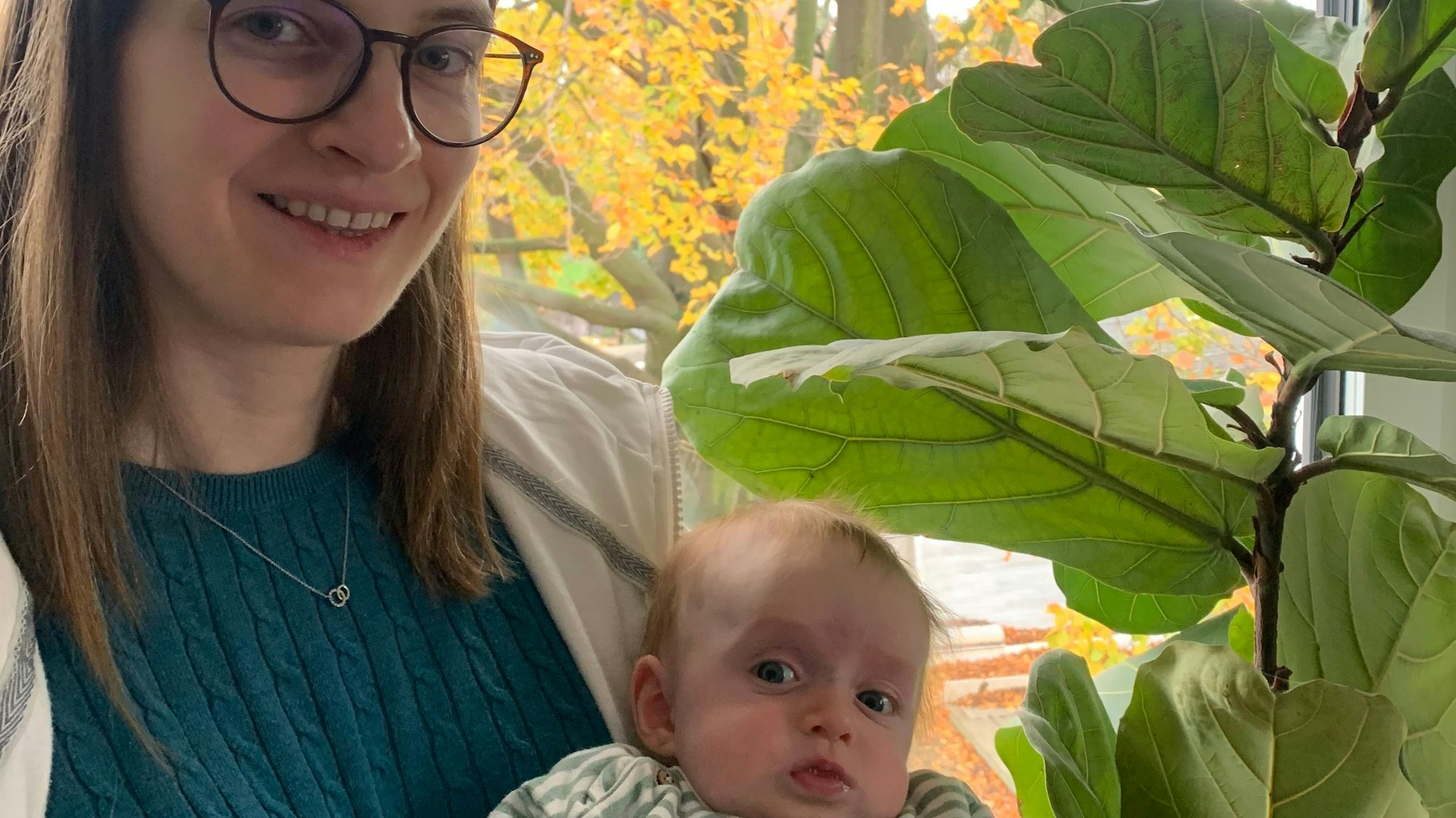 Judith Wittköpper hat ihren Sohn Julius auf dem Arm, im Hintergrund ist die alte Buche zu sehen.