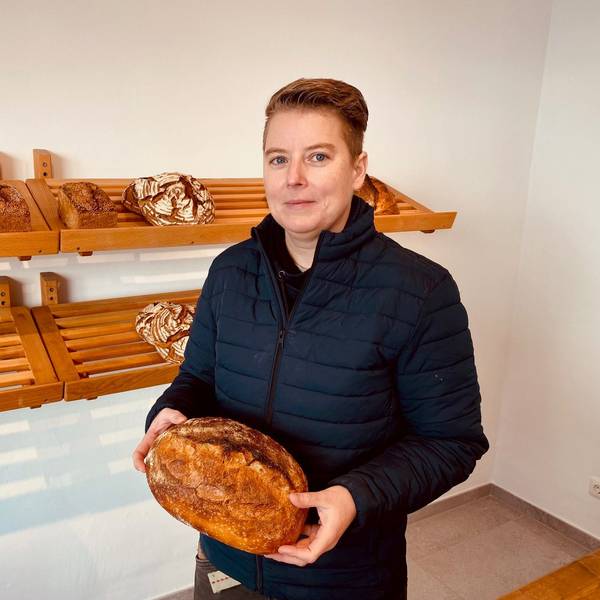 Die neue Inhaberin hält ein Brot in der Hand.