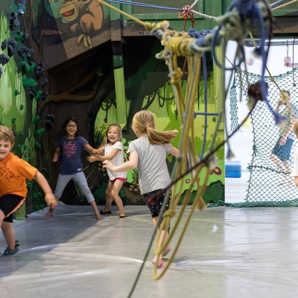 Kinder toben im Stuntwerk Köln in einer Halle.