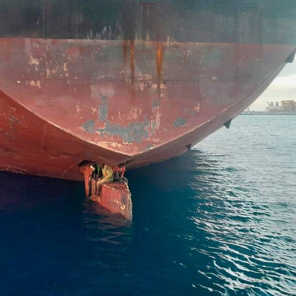 Spanien, Las Palmas: Drei Männer sitzen an einer ungewöhnlichen und gefährlichen Stelle eines Öltankers, der in einem Hafen der Kanarischen Inseln vor Anker liegt.
