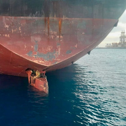 Spanien, Las Palmas: Drei Männer sitzen an einer ungewöhnlichen und gefährlichen Stelle eines Öltankers, der in einem Hafen der Kanarischen Inseln vor Anker liegt.