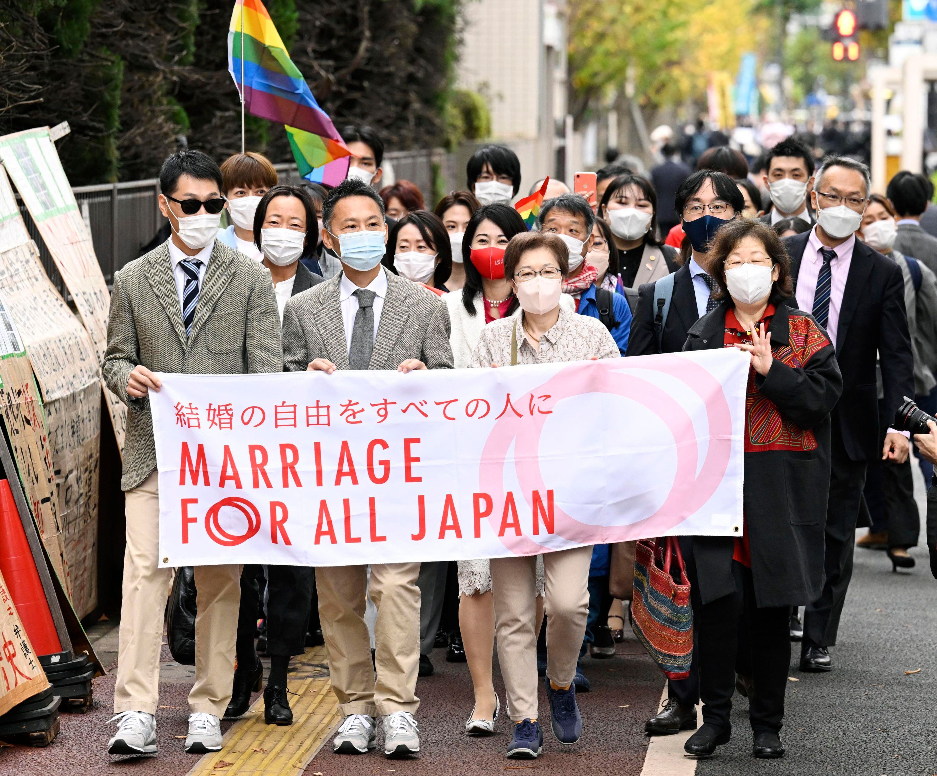 Unterstützer der „Ehe für alle“ laufen zum Bezirksgericht in Tokio. Sie halten ein Banner mit der Aufschrift „Ehe für ganz Japan“ hoch.