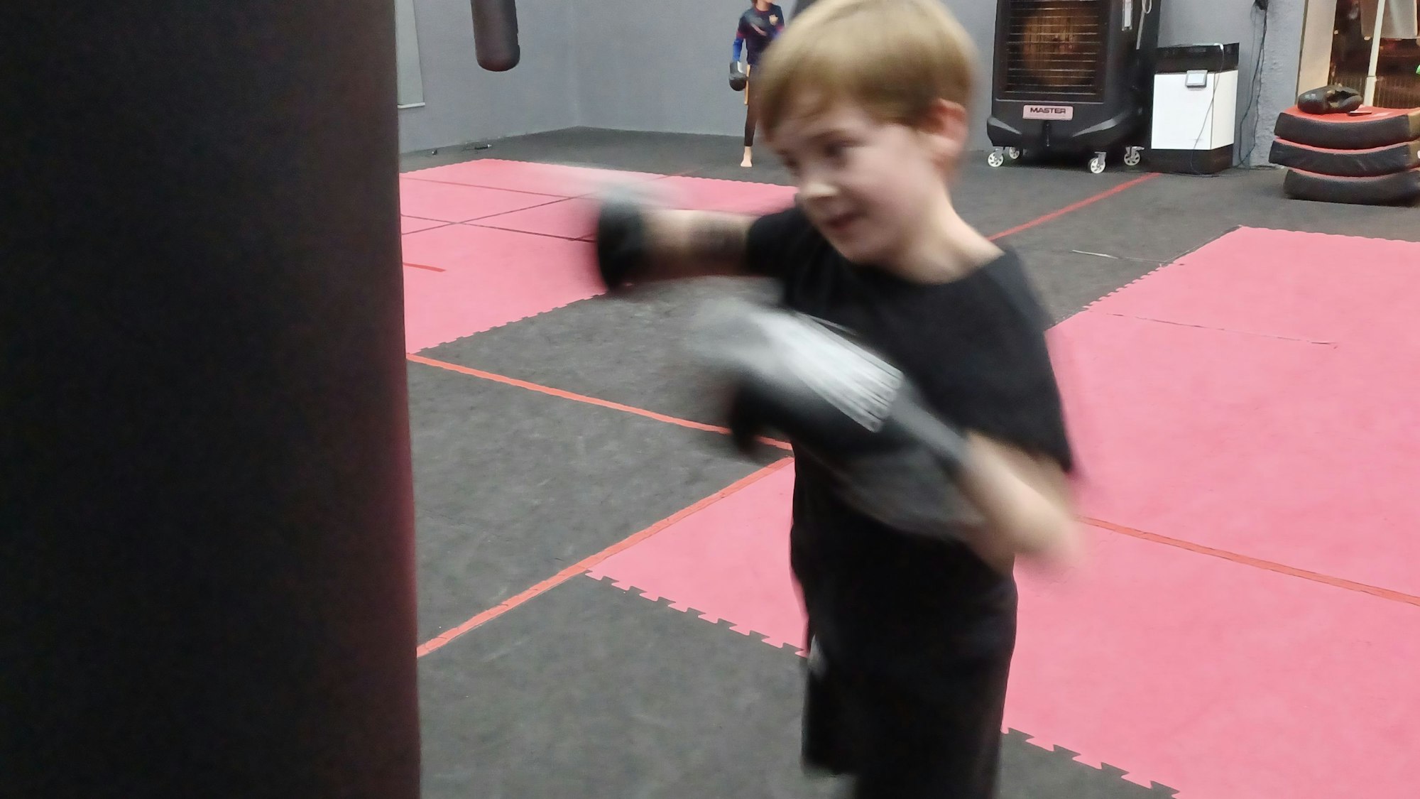 Ein Junge boxt in der Boxing Company Cologne gegen einen Boxsack.