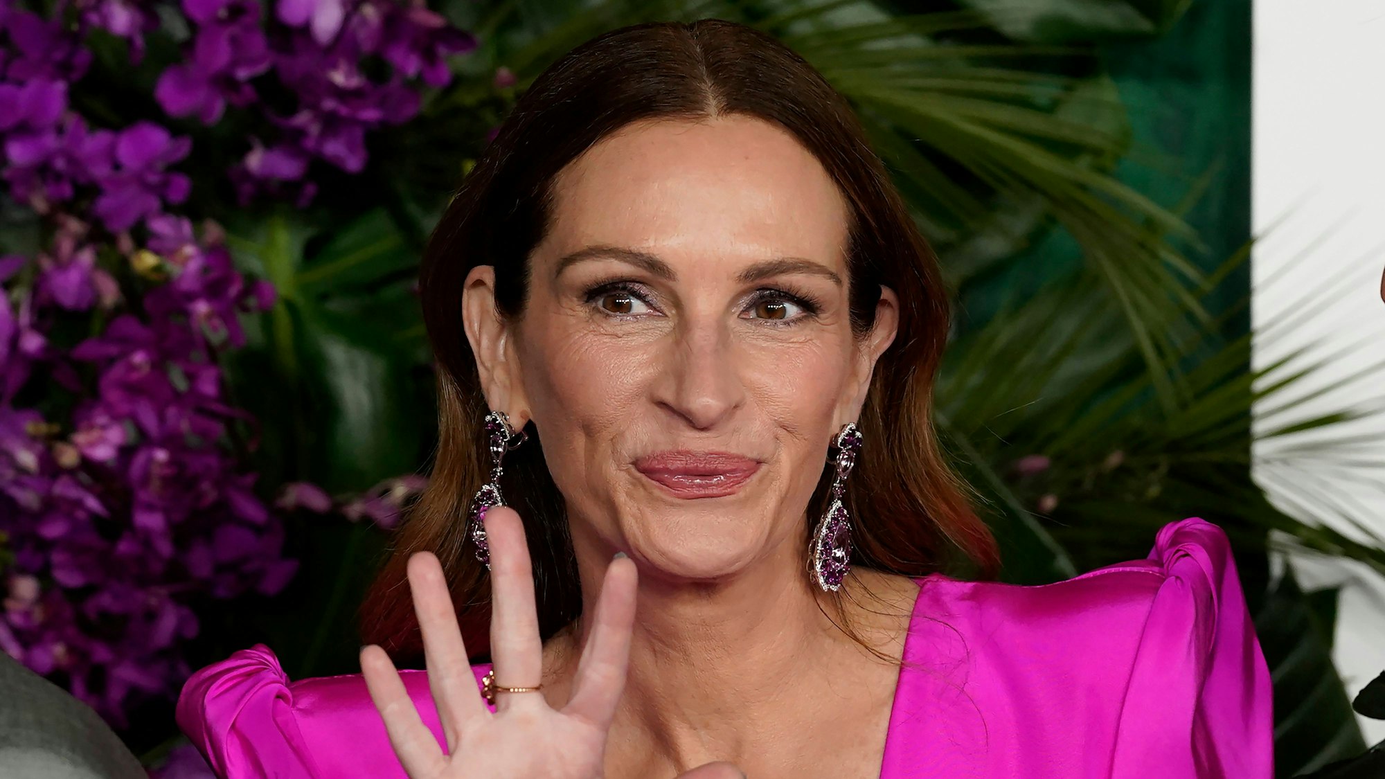 Julia Roberts lacht und winkt in die Kamera.