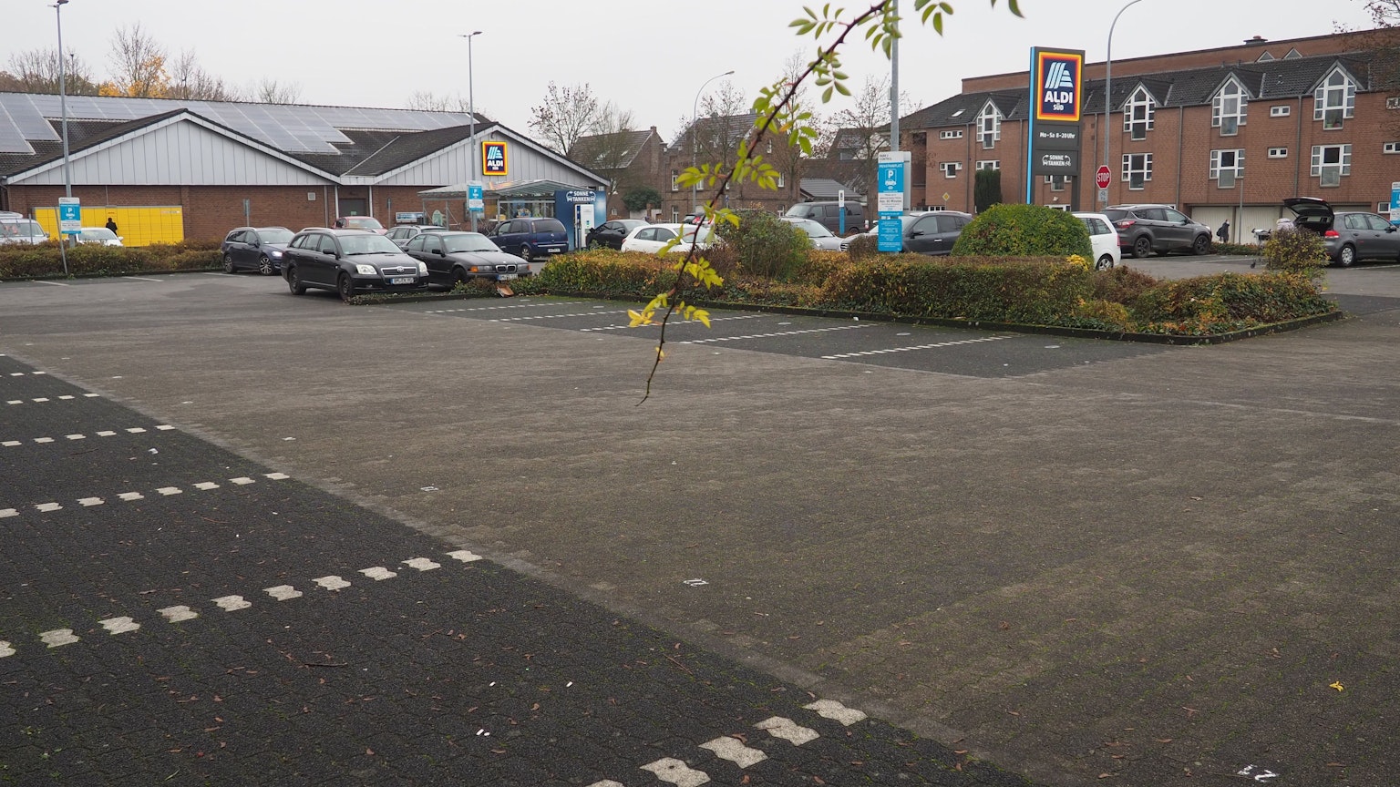 Auf dem Aldi-Parkplatz an der Köttinger Straße soll ein Drogeriemarkt entstehen. Im Hintergrund sieht man den Aldi-Markt, davor ist der Parkplatz zu sehen.