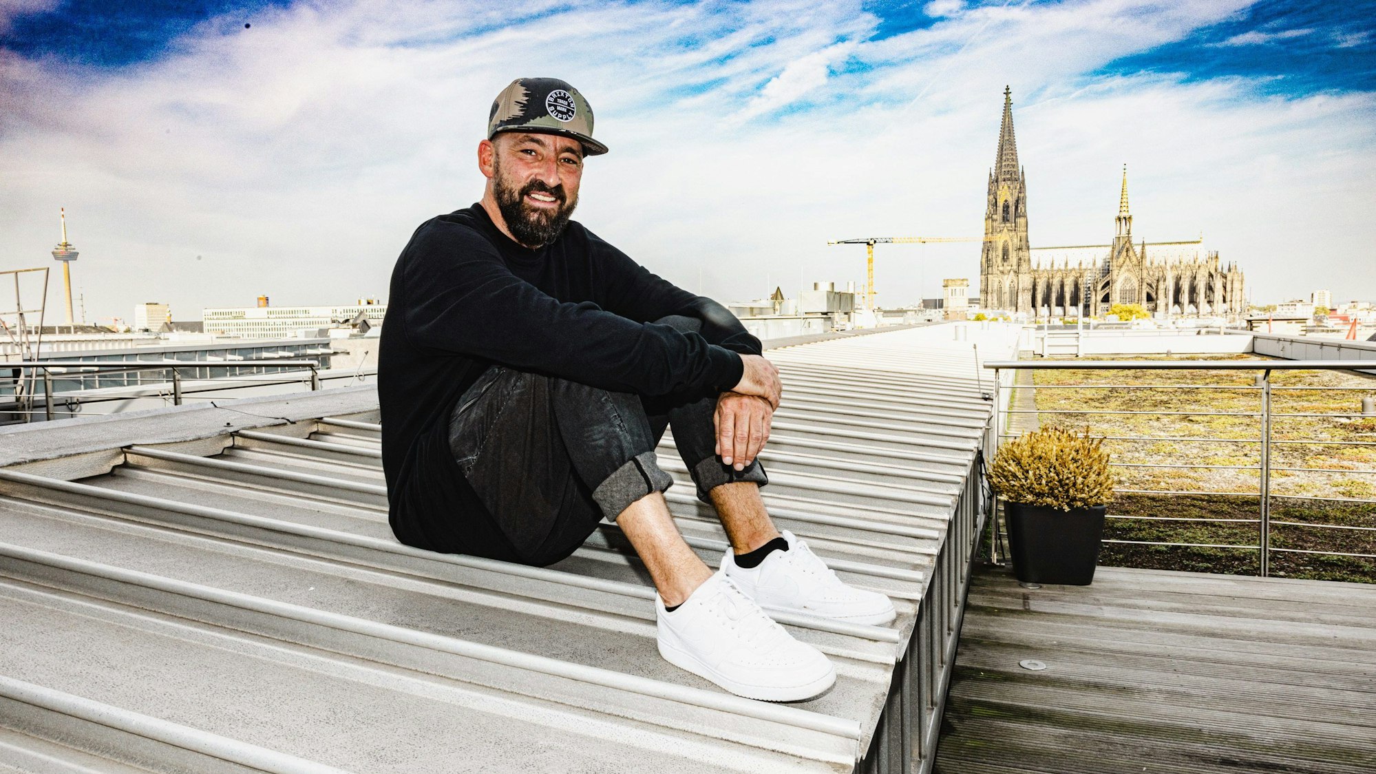 Über den Dächern von Köln sitzt der Musiker Gentleman.