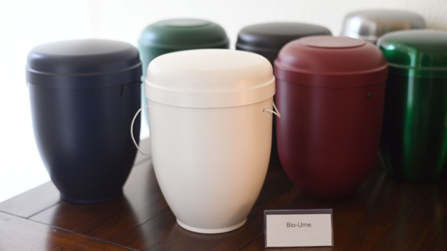 Das Bild zeigt mehrere Urnen auf einem Tisch.