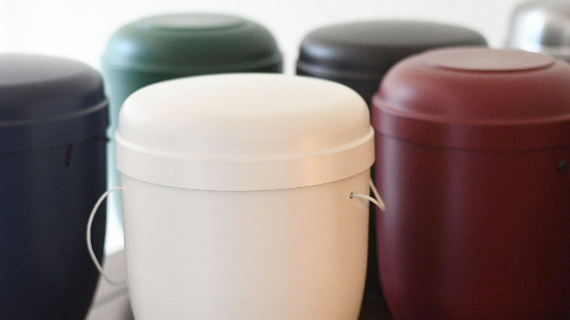 Das Bild zeigt mehrere Urnen auf einem Tisch.