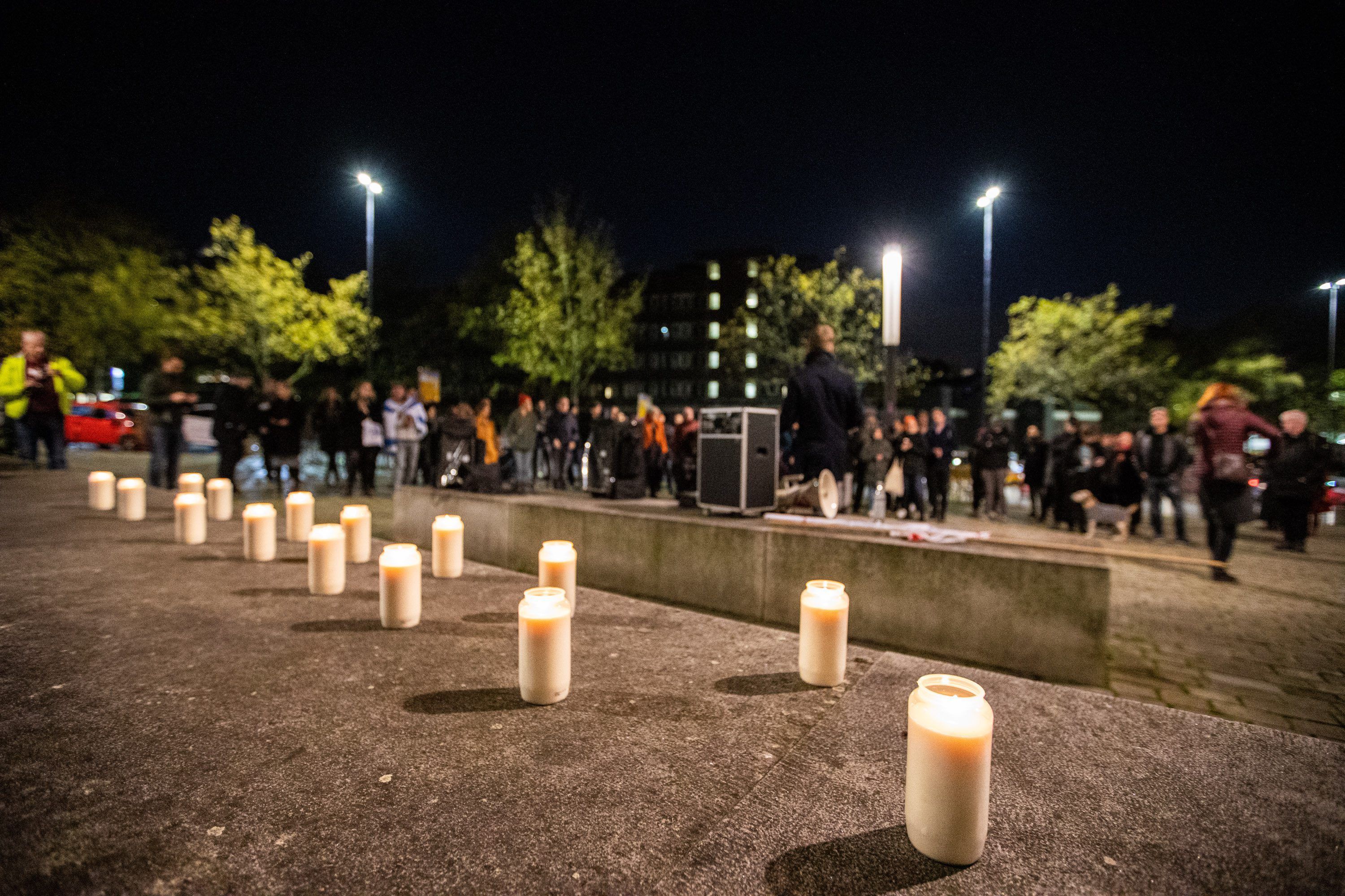 Kerzen stehen bei einer Mahnwache an der Synagoge in Essen auf dem Boden.
