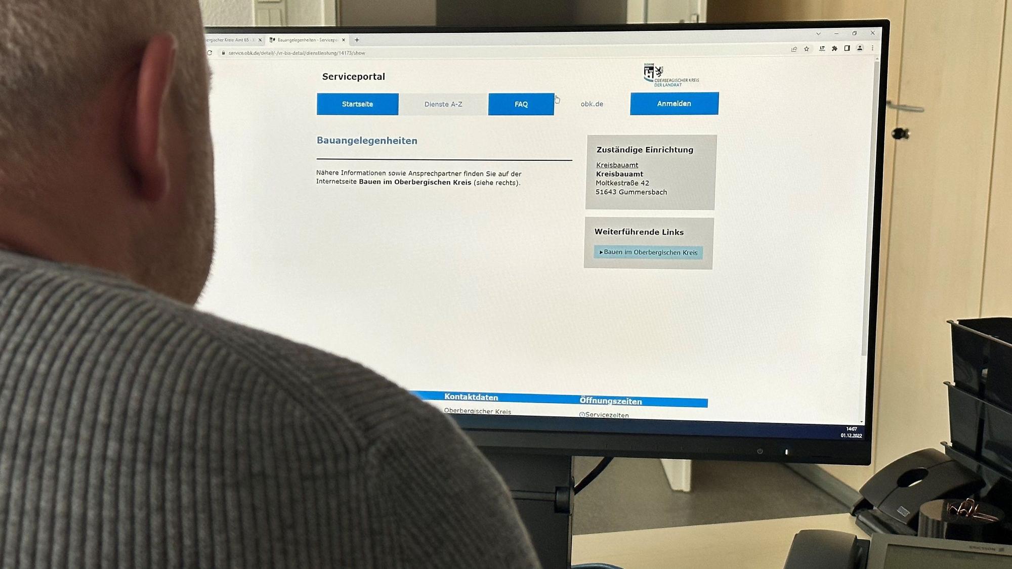 Ein Mann sitzt vor einem Computer-Bildschirm, auf dem die neue Seite des Bauamts zu sehen ist.