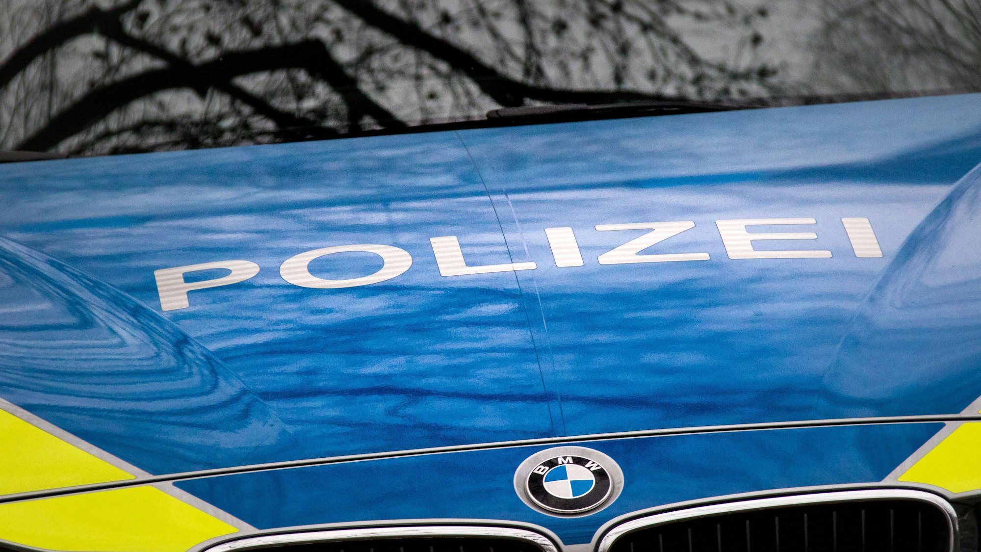 Der Schriftzug „Polizei“ ist auf einem Streifenwagen v Polizei des Landes Nordrhein-Westfalen (NRW) mit dem BMW-Logo auf der Motorhaube zu sehen.