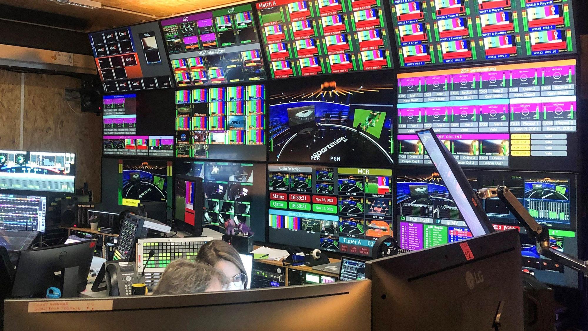 Blick in den technischen Kontrollraum im WM-Sendezentrum von ARD und ZDF in Mainz. An der Wand hängen Dutzende Bildschirme.