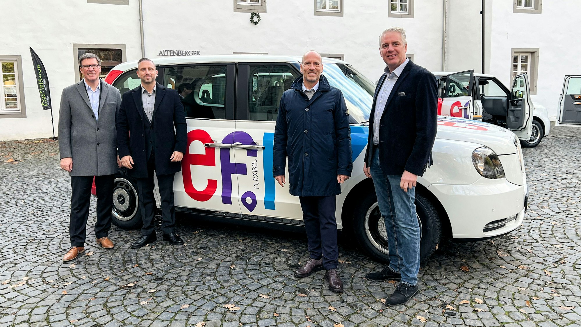 Menschen stehen in Odenthal-Altenberg vor einem Auto mit der Aufschrift „efi“.