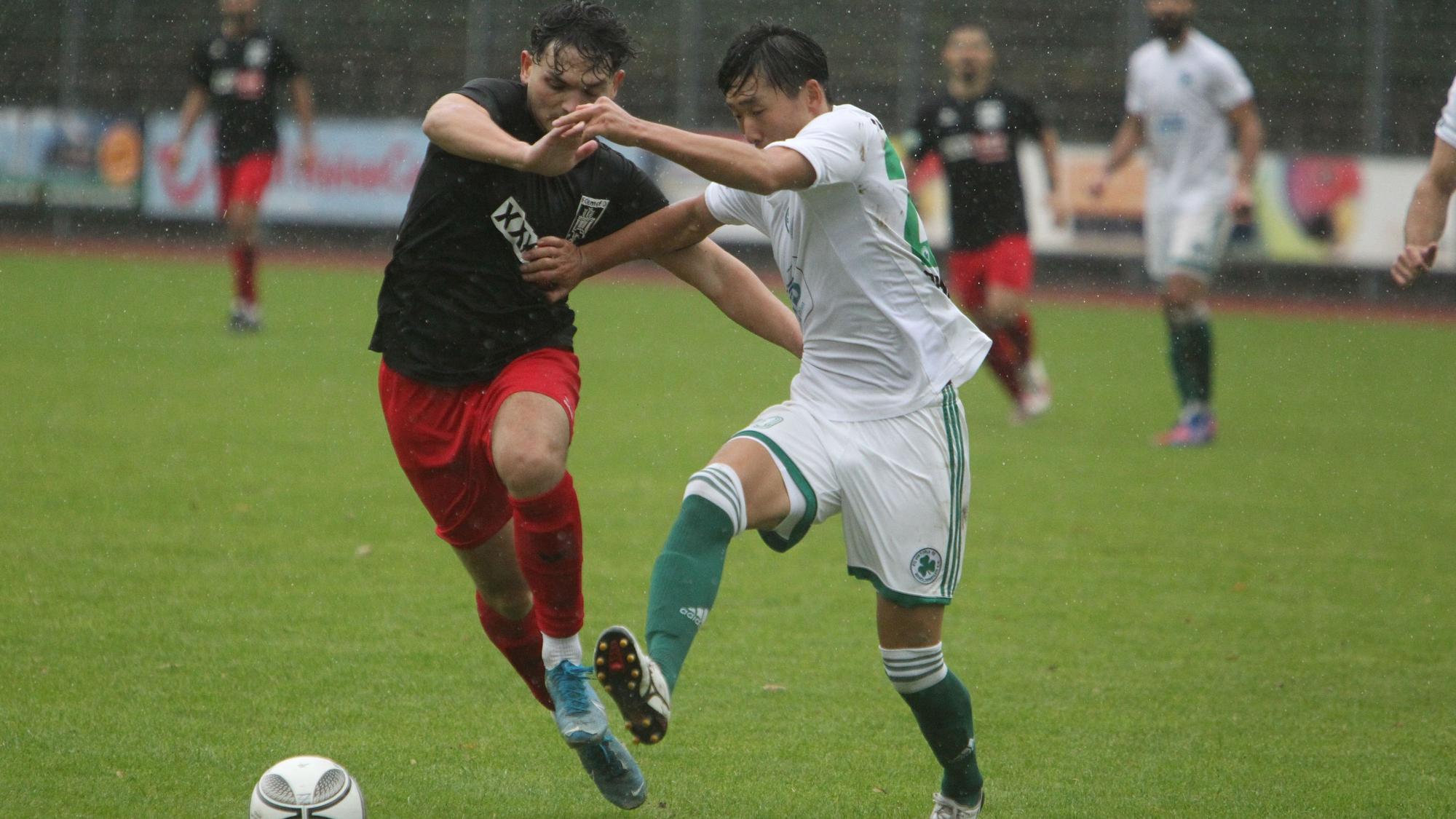 Der Hennefer Akteur Johannes Siregar sprintet dem Ball hinterher und hält sich seinen Gegenspieler mit Armeinsatz vom Leib.