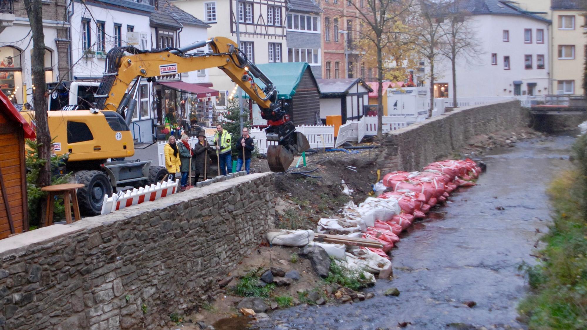 Ein Bagger steht an der Erft in Bad Münstereifel. Dort wird nun eine Freitreppe gebaut.