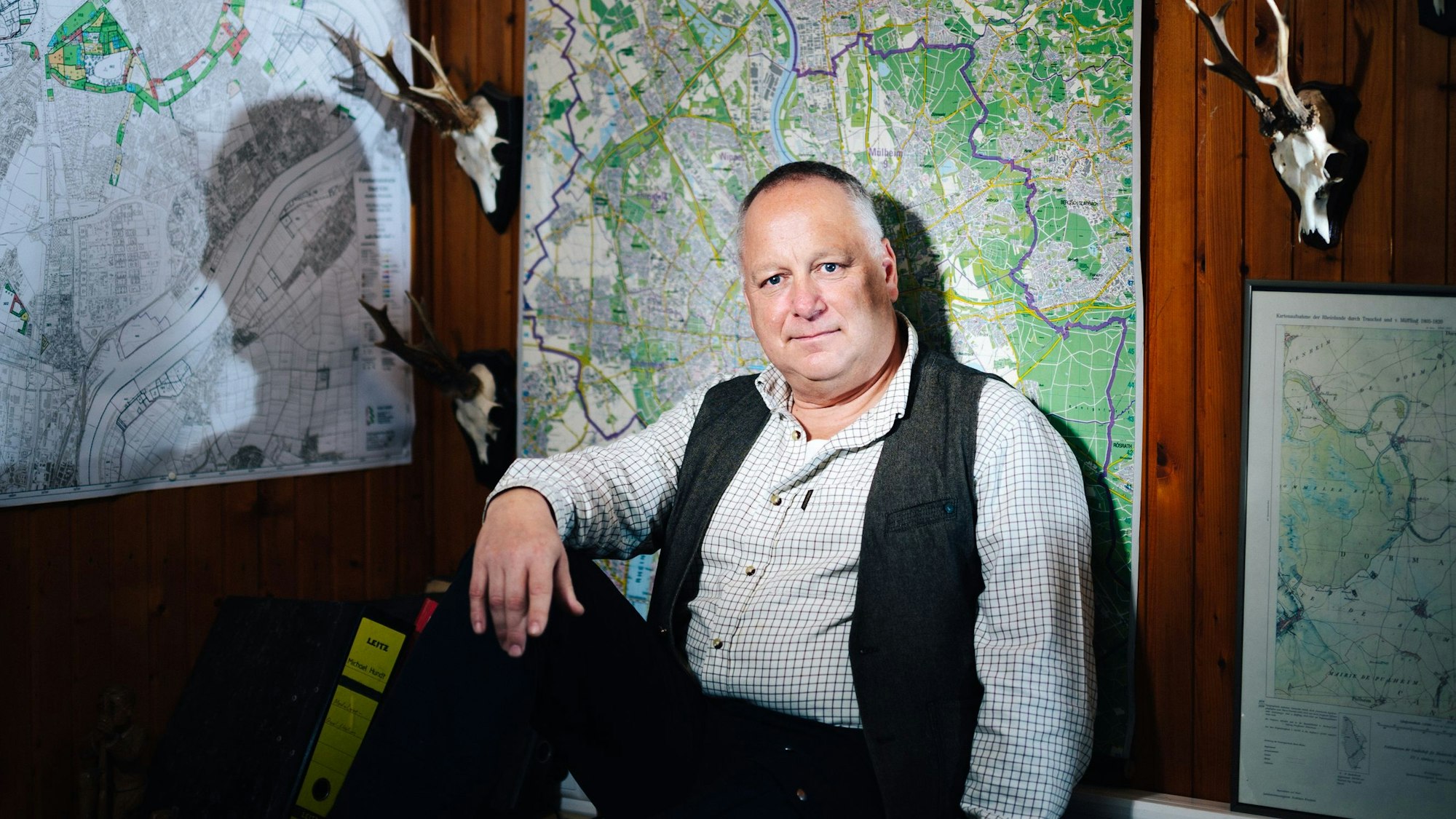 Michael Hundt sitzt in seinem Forsthaus vor einer Landkarte.