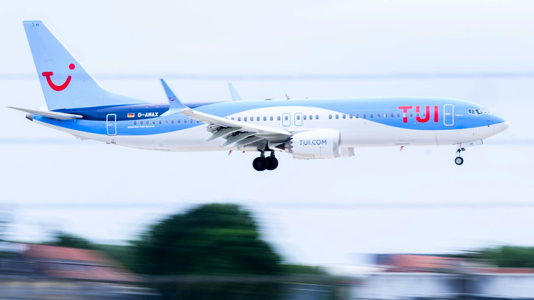 Eine Boeing 737 Max 8 der Fluggesellschaft Tui ist im Landeanflug. Die Maschine ist in weiß und blau gestrichen.