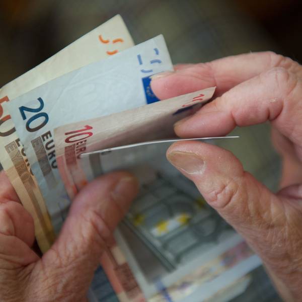 Eine ältere Frau zählt Geld.