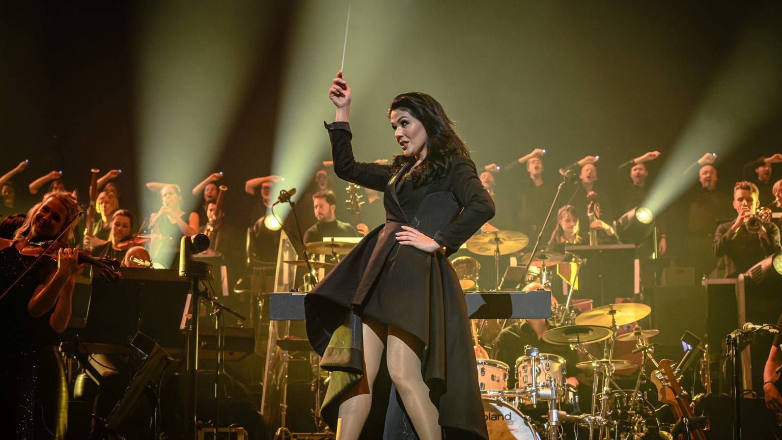 Ein Hauch von Alice im Wunderland: Dirigentin Alexandra Arrieche hat das Publikum und das Antwerp Philharmonic Orchestra gleichermaßen gut im Griff. In einem schwarzen kurzen Mantelkleid mit knöchellanger weiter Schleppe fegte sie auf hohen Schuhen über die Bühne.